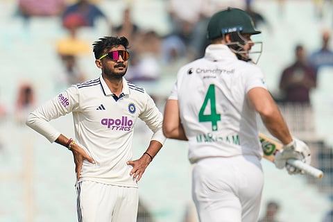 India's Axar Patel, left, reacts after South Africa's Aiden Markram, right, hit a boundary on his delivery on the first day of the first cricket test match between India and South Africa in Kolkata.