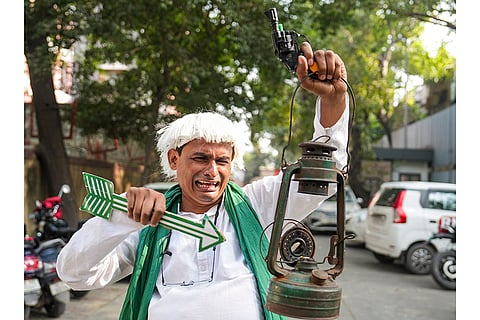 A Janata Dal (United) supporter reacts while celebrating the party's lead in the Bihar Assembly elections as early trends indicate the NDA crossing the majority mark, at the BJP Headquarters in New Delhi.