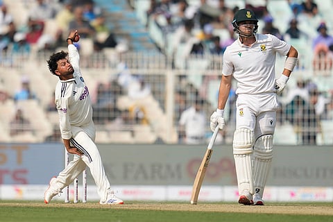 India's Kuldeep Yadav, left, bowls a delivery on the first day of the first cricket test match between India and South Africa in Kolkata.