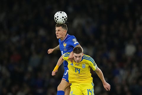 France's Lucas Digne jumps for the ball against Ukraine's Oleh Ocheretko during a World Cup 2026 group D qualifying soccer match between France and Ukraine in Paris.