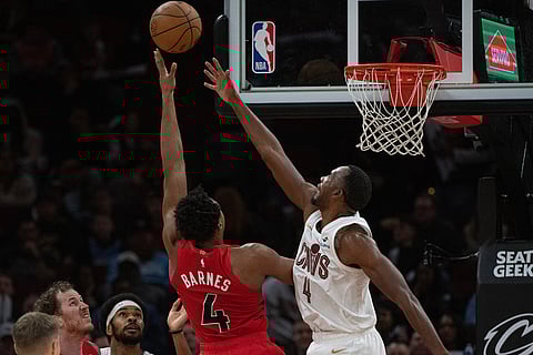 Toronto Raptors' Scottie Barnes, left, shoots over Cleveland Cavaliers' Evan Mobley, right, during the second half of an NBA basketball game in Cleveland.