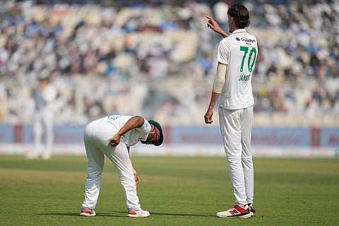 South Africa's captain Temba Bavuma, left, rubs to shine the ball as teammate Marco Jansen prepares to bowl his next delivery on the second day of the first cricket test match between India and South Africa in Kolkata.