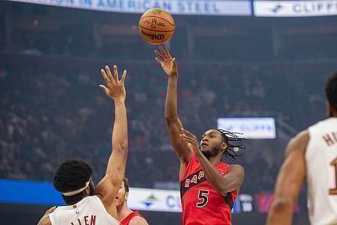 Toronto Raptors' Immanuel Quickley (5) shoots over Cleveland Cavaliers' Jarrett Allen, left, during the first half of an NBA basketball game in Cleveland.