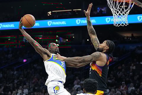 Indiana Pacers guard Aaron Nesmith (23) drives on Phoenix Suns center Nick Richards during the second half of an NBA basketball game in Phoenix.