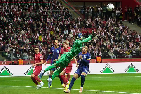 Poland goalkeeper Kamil Grabara punches the ball away during a World Cup 2026 group G qualifying soccer match between Poland and the Netherlands in Warsaw.