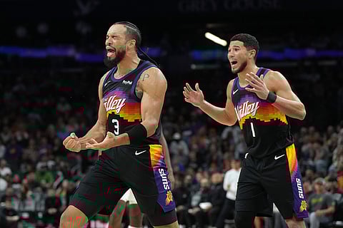 Phoenix Suns forward Dillon Brooks (3) and guard Devin Booker (1) react after foul calls against the Indiana Pacers during the second half of an NBA basketball game in Phoenix. 