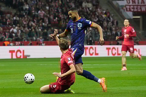 Poland's Jan Ziolkowski, left, tries to tackle Netherlands' Cody Gakpo during a World Cup 2026 group G qualifying soccer match between Poland and the Netherlands in Warsaw.