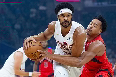 Cleveland Cavaliers' Jarrett Allen, left, steals the ball from Toronto Raptors' Scottie Barnes, right, during the first half of an NBA basketball game in Cleveland.