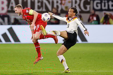 Luxembourg's Laurent Jans, left, fights for the ball with Germany's Leroy Sane during the 2026 World Cup group A qualifying soccer match between Luxembourg and Germany in Luxembourg.