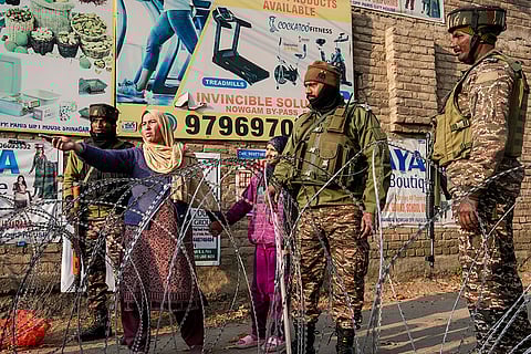 A woman seeks permission from security personnel to enter a blocked road leading to the Nowgam police station, where an accidental explosion occured late Friday night, killing at least nine people, in Srinagar.