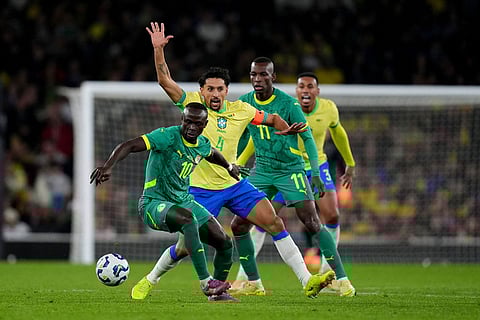 Senegal's Sadio Mane, front, and Brazil's Marquinhos battle for the ball during an international soccer match between Brazil and Senegal at the Emirates Stadium, London.