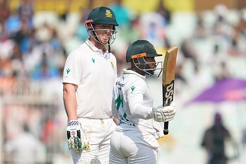 South Africa's Simon Harmer, left, watches as batting partner and captain Temba Bavuma celebrates after scoring fifty runs on the third day of the first cricket test match between India and South Africa in Kolkata, India.