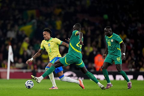 Brazil's Eder Militao, left, and Senegal's Pape Gueye battle for the ball during an international soccer match between Brazil and Senegal at the Emirates Stadium, London.