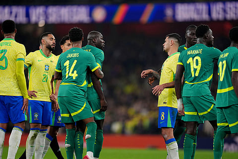 Senegal's Kalidou Koulibaly is restrained by teammates after an altercation with Brazil's Bruno Guimaraes during an international soccer match between Brazil and Senegal at the Emirates Stadium, London.