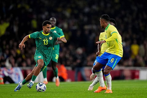 Senegal's Iliman Ndiaye, left, and Brazil's Alex Sandro battle for the ball during an international soccer match between Brazil and Senegal at the Emirates Stadium, London.