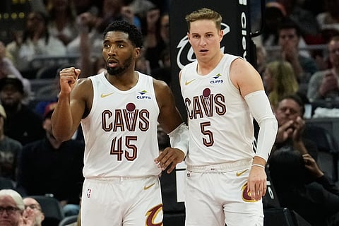 Cleveland Cavaliers guard Donovan Mitchell (45) pumps his fist after guard Sam Merrill (5) hit a basket in the second half of an NBA basketball game against the Memphis Grizzlies in Cleveland. 