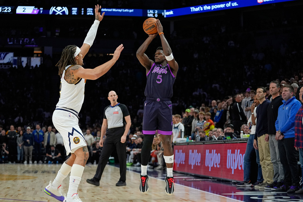 Minnesota Timberwolves guard Anthony Edwards (5) shoots over Denver Nuggets forward Aaron Gordon (32) during the first half of an NBA basketball game in Minneapolis. 