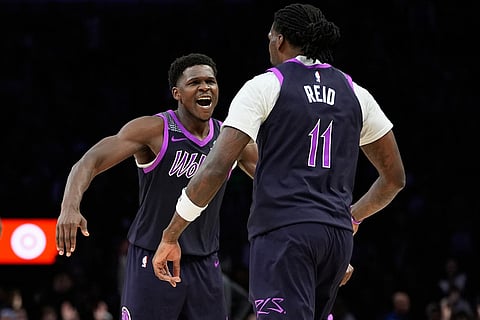 Minnesota Timberwolves guard Anthony Edwards (5) celebrates after a 3-point shot made by center Naz Reid (11) during the first half of an NBA basketball game against the Denver Nuggets in Minneapolis. 