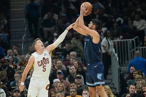 Memphis Grizzlies forward Santi Aldama, right, shoots over Cleveland Cavaliers guard Sam Merrill (5) in the first half of an NBA basketball game in Cleveland. 