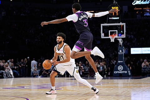 Denver Nuggets guard Jamal Murray (27) prepares to shoot as Minnesota Timberwolves forward Jaden McDaniels (3) defends during the second half of an NBA basketball game in Minneapolis. 