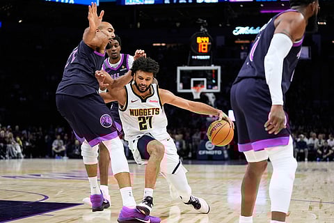 Denver Nuggets guard Jamal Murray (27) works toward the basket as Minnesota Timberwolves center Rudy Gobert, left, defends during the second half of an NBA basketball game in Minneapolis.