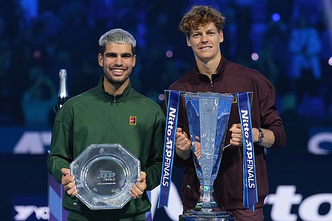 Spain's Carlos Alcaraz, left, and winner Italy's Jannik Sinner stand on the podium after the final tennis match of the ATP World Tour Finals, in Turin, Italy.