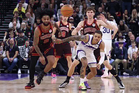 Chicago Bulls guard Coby White (0) and Utah Jazz guard Keyonte George, right, battle for a loose ball during the first overtime of an NBA basketball game in Salt Lake City. 