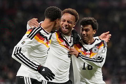 Germany's Assan Ouedraogo, center, celebrates after scoring during a group A World Cup qualifiying soccer match between Germany and Slovakia in Leipzig, Germany.