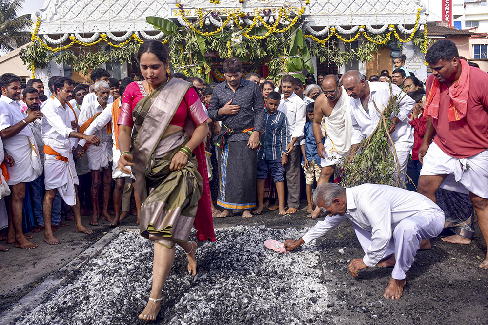 A woman walks on embers during the religious festival of 'Veerabhadreshwara Kondotsava', in Chikkamagaluru, Karnataka. 