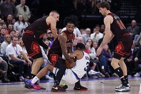 Chicago Bulls guard Coby White, second from left, ties up Utah Jazz guard Keyonte George (3) for a jump ball during the first overtime of an NBA basketball game in Salt Lake City. 
