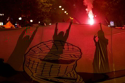 Demonstrators hold flares during a protest against Israel's military actions in Gaza, ahead of a friendly match between a selection of Palestinian players and a group of Spanish players from the Basque Country, in Bilbao, Spain.