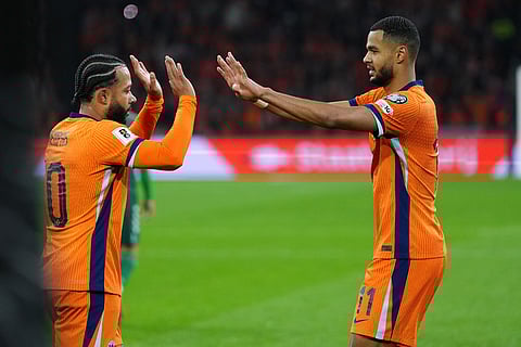 Netherlands' Cody Gakpo is congratulated by Memphis Depay after scoring his side's 2nd goal from the penalty spot during a World Cup 2026 group G qualifying soccer match between Netherlands and Lithuania in Amsterdam, Netherlands.