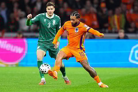 Netherlands' Memphis Depay, front, controls the ball followed by Lithuania's Edgaras Utkus during a World Cup 2026 group G qualifying soccer match between Netherlands and Lithuania in Amsterdam, Netherlands.