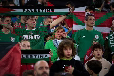 Fans wave Palestinian flags and flags of the northern Basque Country region during a friendly match between a selection of Palestinian players and a group of Spanish players from the Basque Country, held to protest Israel's military actions in Gaza, in Bilbao, Spain.