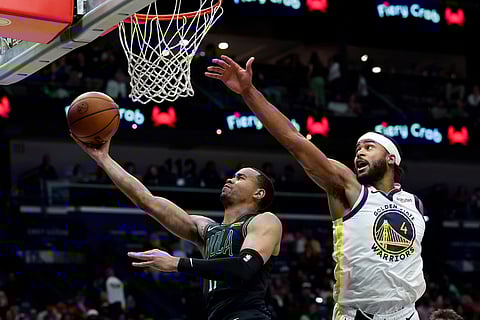 New Orleans Pelicans guard Bryce McGowens lays in a basket as Golden State Warriors guard Moses Moody (4) defends during the fourth quarter of an NBA basketball game in New Orleans.