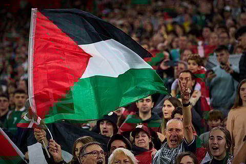 Fans wave Palestinian flags during a friendly match between a selection of Palestinian players and a group of Spanish players from the Basque Country, held to protest Israel's military actions in Gaza, in Bilbao, Spain.