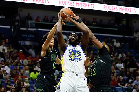 New Orleans Pelicans center Derik Queen (22) and guard Jeremiah Fears (0) strip the ball from Golden State Warriors forward Draymond Green (23) as he goes to the basket during the first quarter of an NBA basketball game in New Orleans. 