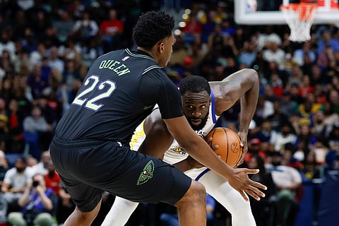 Golden State Warriors forward Draymond Green tries to get around New Orleans Pelicans center Derik Queen (22) during the second quarter of an NBA basketball game in New Orleans. 