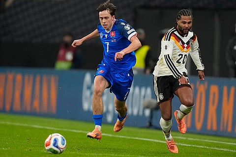 Slovakia's Leo Sauer, left, and Germany's Serge Gnabry run for the ball during a group A World Cup qualifiying soccer match between Germany and Slovakia in Leipzig, Germany.