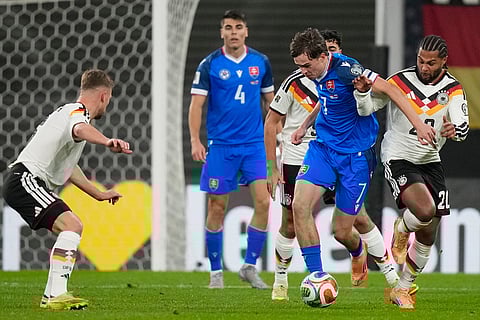 Slovakia's Leo Sauer, left, and Germany's Serge Gnabry fight for the ball during a group A World Cup qualifiying soccer match between Germany and Slovakia in Leipzig, Germany.