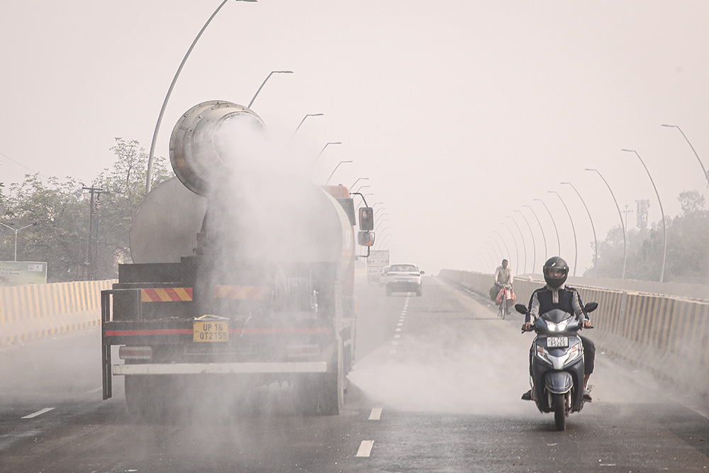 An anti-smog gun sprays water droplets to curb air pollution, in Noida.
