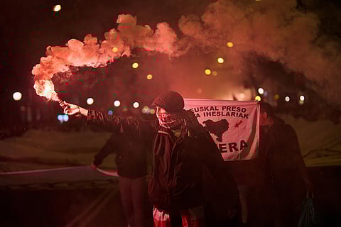 A demonstrator holds a flare during a protest against Israel's military actions in Gaza, ahead of a friendly match between a selection of Palestinian players and a group of Spanish players from the Basque Country, in Bilbao, Spain.