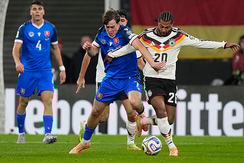 Slovakia's Leo Sauer, left, and Germany's Serge Gnabry fight for the ball during a group A World Cup qualifiying soccer match between Germany and Slovakia in Leipzig, Germany.