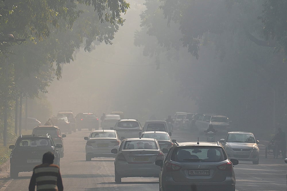 Vehicles ply on a road amid smog as air quality remains in the ‘poor’ category, near Kartavya Path in New Delhi. - | Photo: PTI/Karma Bhutia