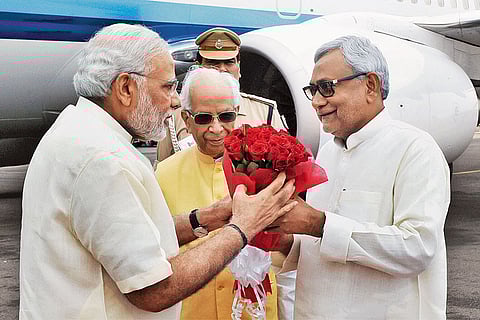 Prime Minister Narendra Modi being welcomed by Governor of Bihar K.N. Tripathi and Chief Minister Nitish Kumar at Patna airport