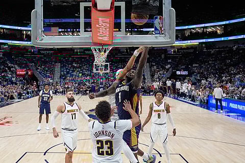 New Orleans Pelicans forward Zion Williamson (1) goes to the basket in front of Denver Nuggets forward Cameron Johnson (23) in the second half of an NBA basketball game in New Orleans. 