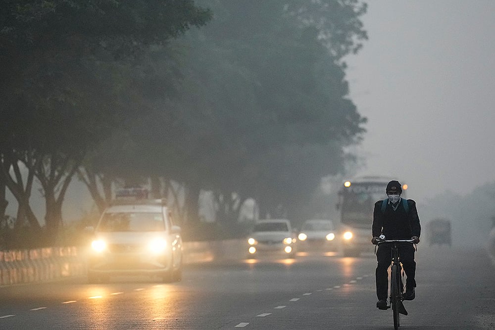 Vehicles ply on a road amid smog as air quality deteriorates, in New Delhi. - | Photo: PTI/Karma Bhutia
