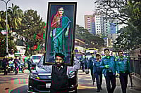 Sentenced To Chaos: Will Delhi Extradite Sheikh Hasina To Bangladesh? | Photo: AP : In ol’ Times: A supporter of Sheikh Hasina carries her giant portrait in Dhaka on December 27, 2018