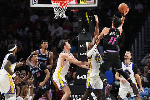 Miami Heat forward Jaime Jaquez Jr. (11) shoots as Golden State Warriors guard Buddy Hield (7) defends during the second half of an NBA basketball game in Miami. 