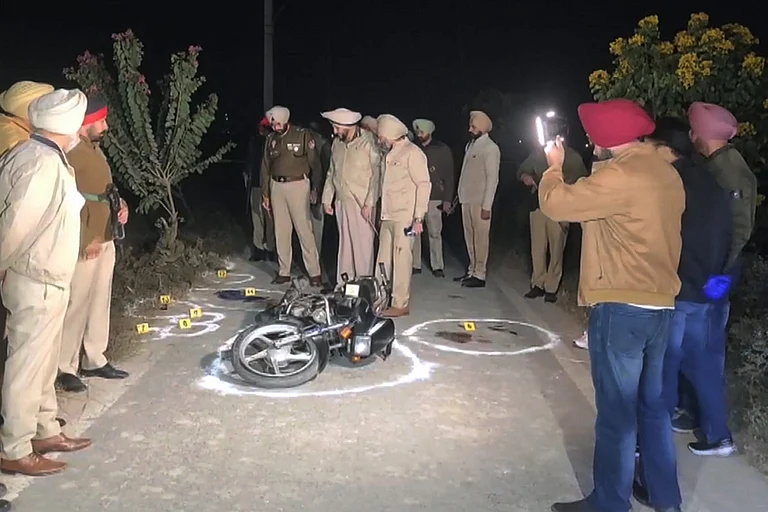 Police Commissioner Gurpreet Singh Bhullar and other officials inspect the site where two youths on a motorcycle allegedly open fire on police during a late-night checkpoint inspection, in Amritsar. One of them succumbs to injuries while the other escapes, prompting a search operation, according to officials. - | Photo: PTI